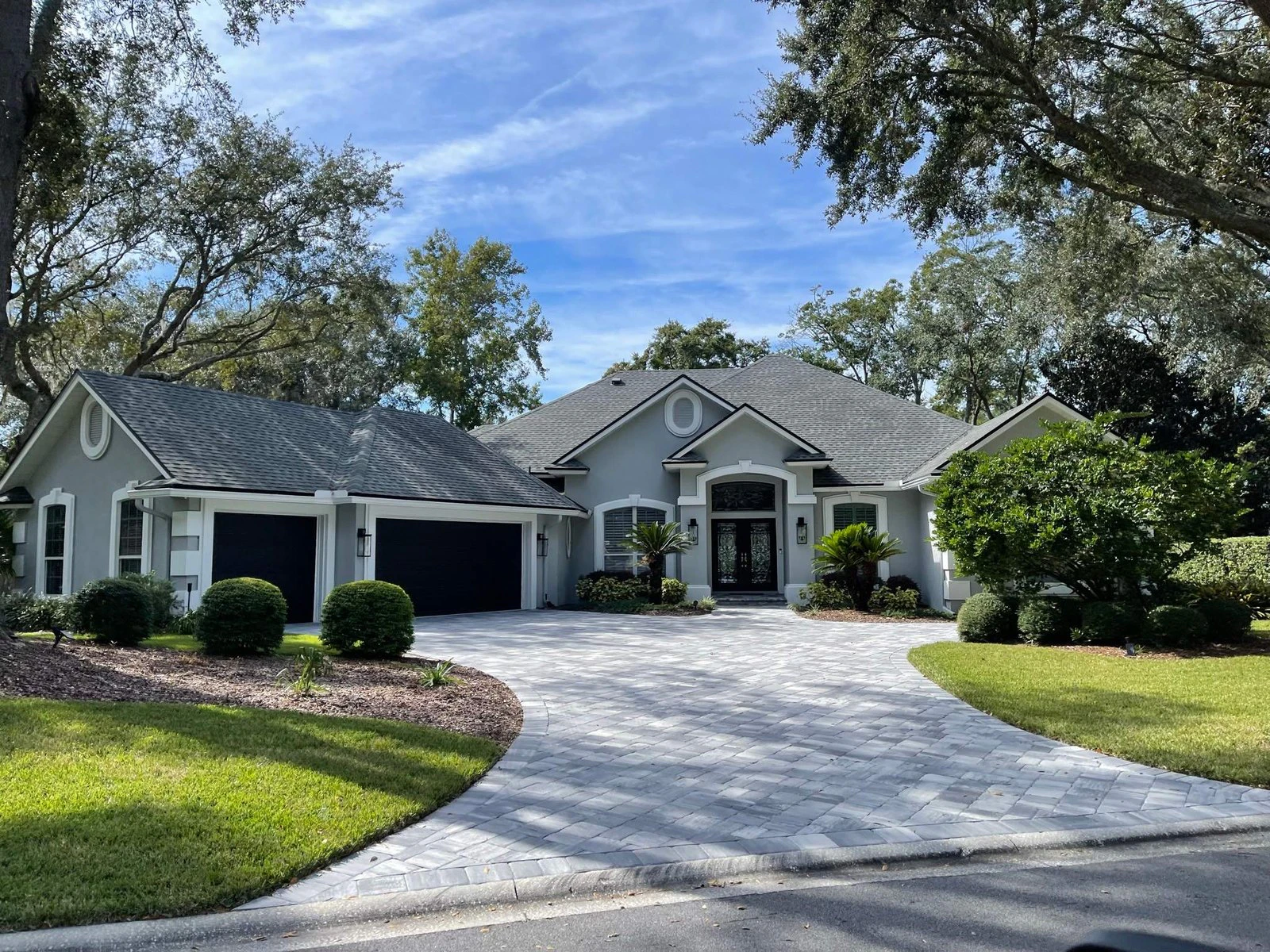 The same Queen’s Harbour home after repainting, in soft slate with white trim and black garage doors, Jacksonville FL 32225